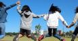 Ragazze che saltano per mano in un parco per bandi pon comune di bologna adolescenti e giovani