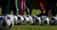 Foto di palloni da calcio su campo sportivo con piedi di calciatori
